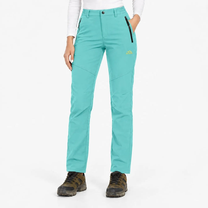 Model draagt de broek in turquoise met zwarte ritszakken en wandelschoenen, vooraanzicht 19
