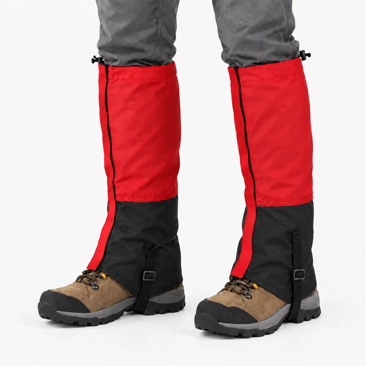 Rode gamaschen met zwart onderstuk en verstelbaar bandje, gedragen over bruine wandelschoenen en een grijze broek. 11
