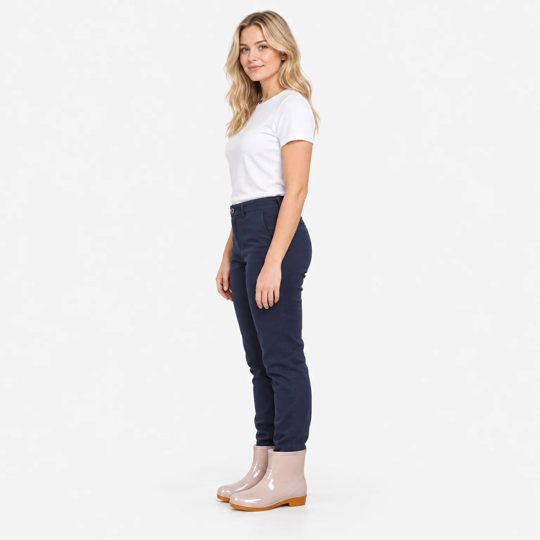 Model met blond haar draagt de roze enkellaarzen met een donkerblauwe broek en wit t-shirt, zijaanzicht op een witte achtergrond. 4