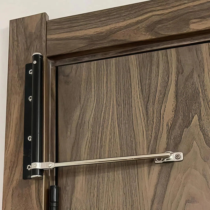 Close-up van een zwarte deursluiter met zilverkleurige arm op een donkere houten deur 3