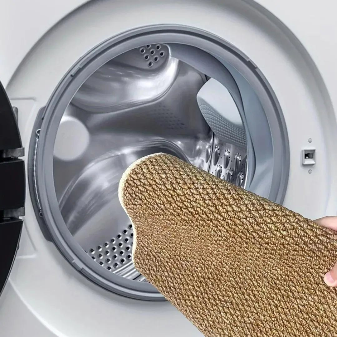 Opgerolde bruine badmat wordt in de trommel van een wasmachine gelegd om te wassen 7