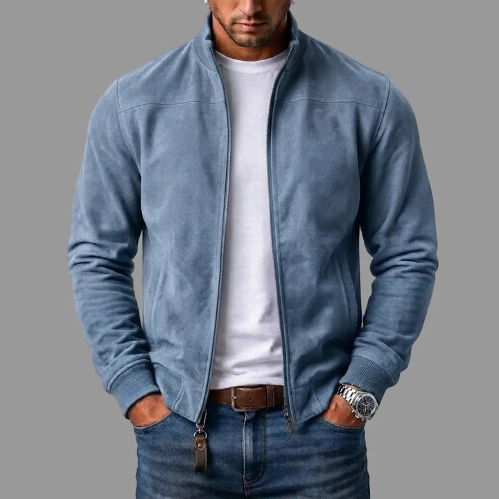 Lichtblauwe suèdelook jack, open gedragen over een wit T-shirt en jeans, met bruin leren sleutelhangertje aan de rits. 4