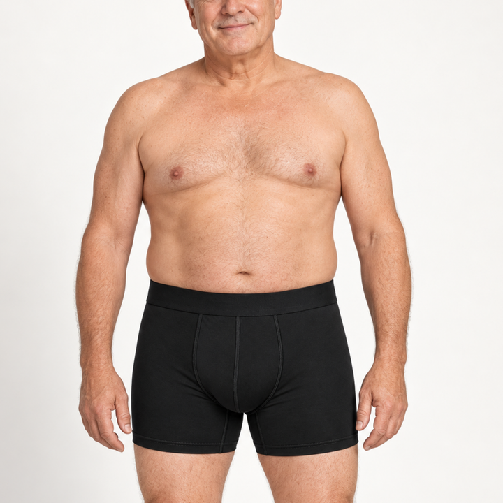 Oudere man draagt een zwarte boxershort met langere pijp, vooraanzicht, frontaal tegen een witte achtergrond. 2