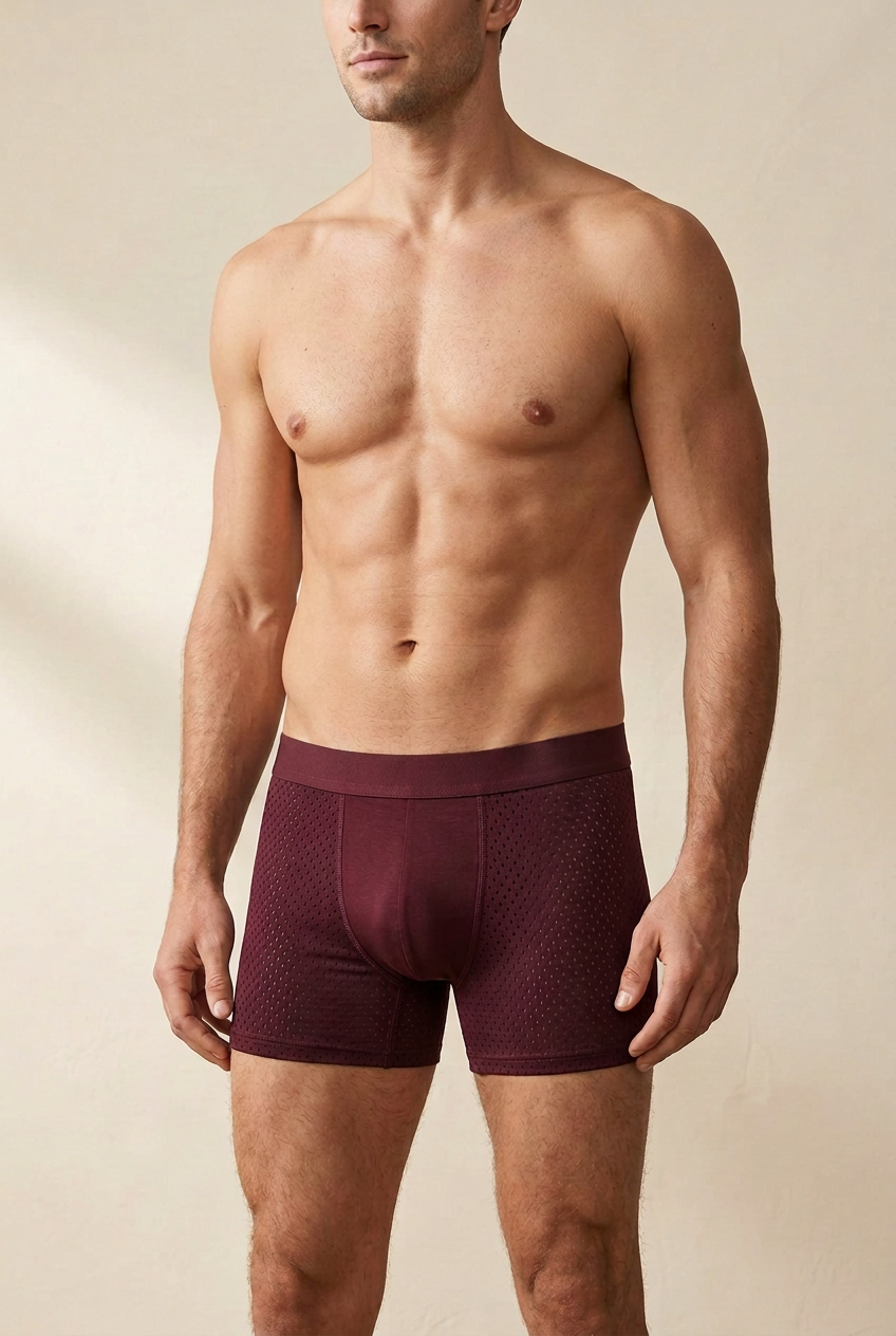 Man met blote borst draagt een bordeauxrode boxershort met geperforeerde zijpanelen, vooraanzicht 1