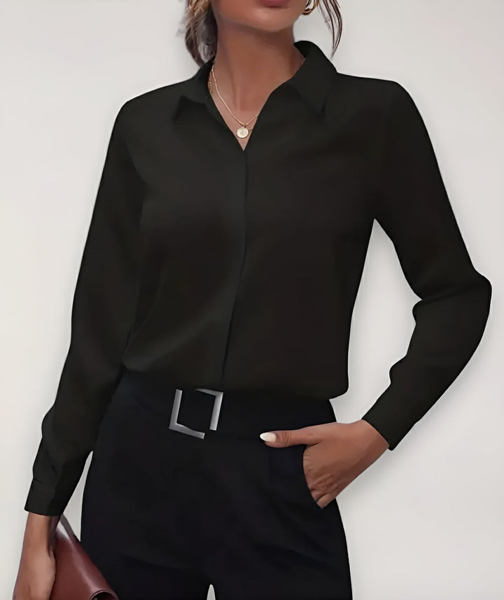 Zwarte blouse gedragen door een model met zwarte broek, riem en bruine tas, voorkant 1
