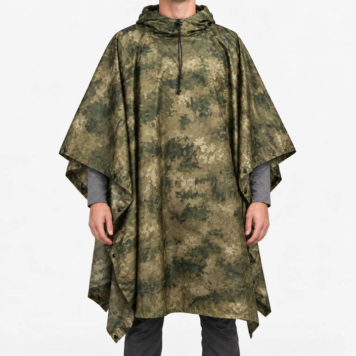 Voorkant van de poncho in wazige groen-olijf camouflageprint met organische vlekken, gedragen door een model op een witte achtergrond. 10