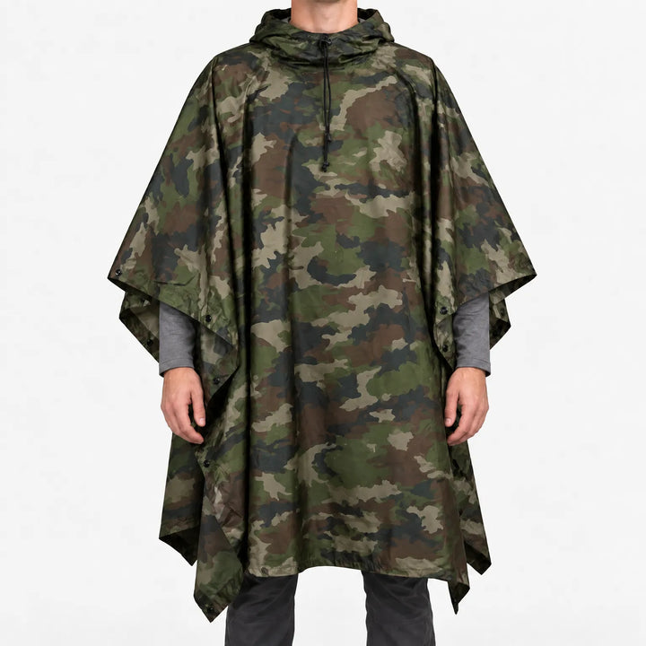 Voorkant van de poncho in klassieke woodland-camouflageprint met groene, bruine en zwarte vlekken, gedragen door een model op een witte achtergrond. 14