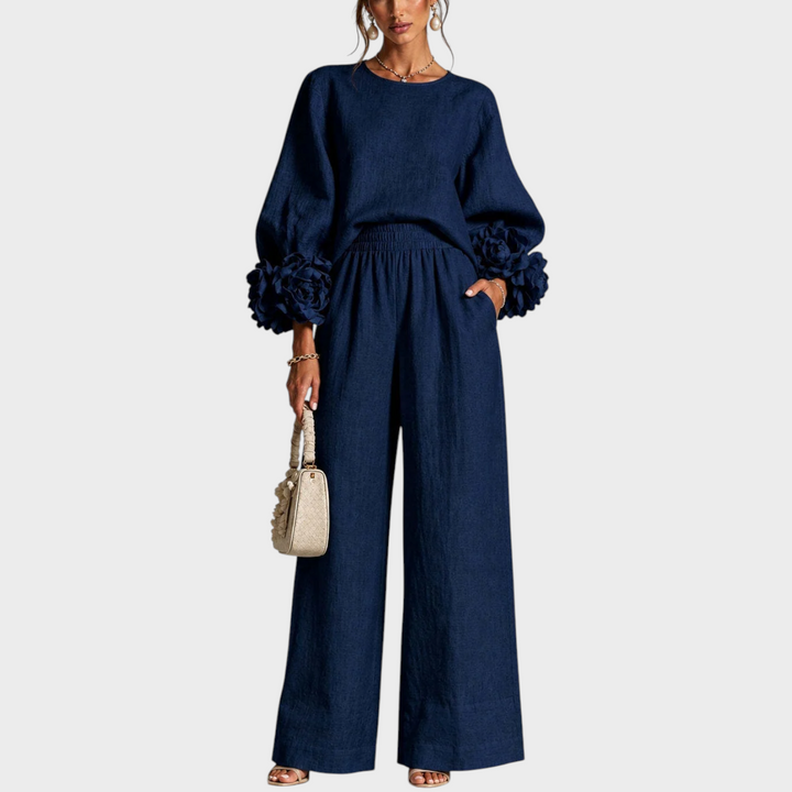 Model in donkerblauwe set met bloemen aan de mouwmanchetten en wijde broek, vooraanzicht 2
