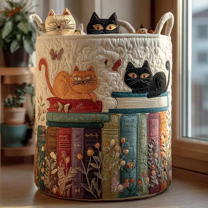 Crème gewatteerde mand met geborduurde oranje en zwarte kat op een stapel boeken, staand op een vensterbank met kleine poezenfiguurtjes bovenop. 1