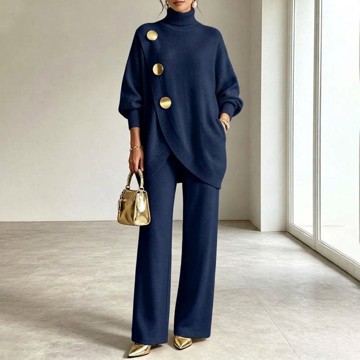 Gebreide set in marineblauw met gouden knopen op de overslagtop, gedragen met wijde broek en gouden schoenen. 5