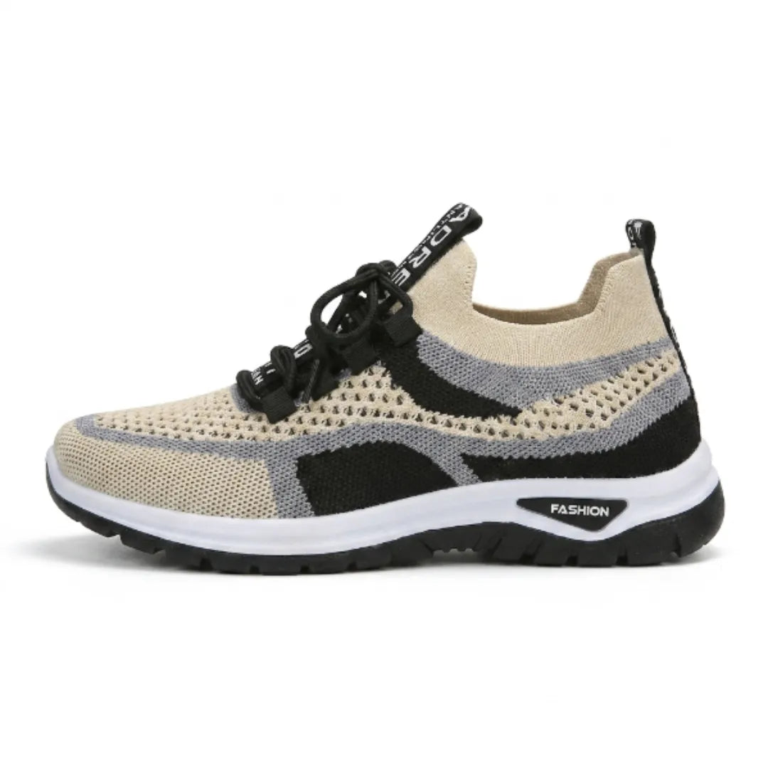 Zijaanzicht van de beige sneaker met zwarte en grijze mesh, zwarte veters, witte tussenzool en zwarte loopzool. 37