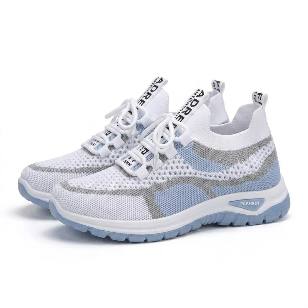 Paar witte mesh sneakers met lichtblauwe zool en grijze strepen, schuin van voren gefotografeerd. 7