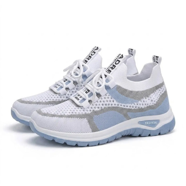 Paar witte mesh sneakers met lichtblauwe zool en grijze strepen, schuin van voren gefotografeerd. 7