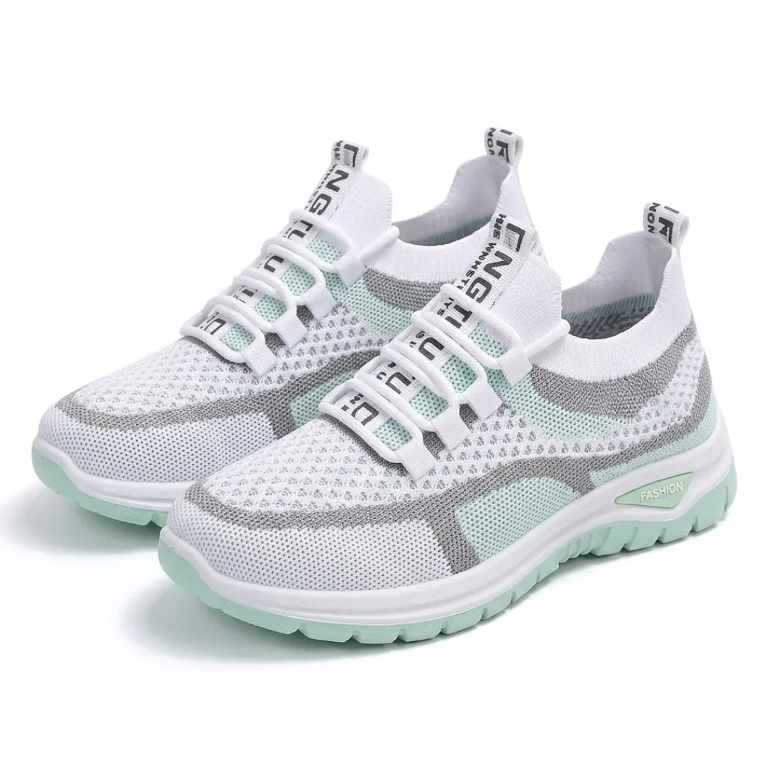Paar witte mesh sneakers met mintgroene zool en grijze strepen, schuin van voren gefotografeerd. 16