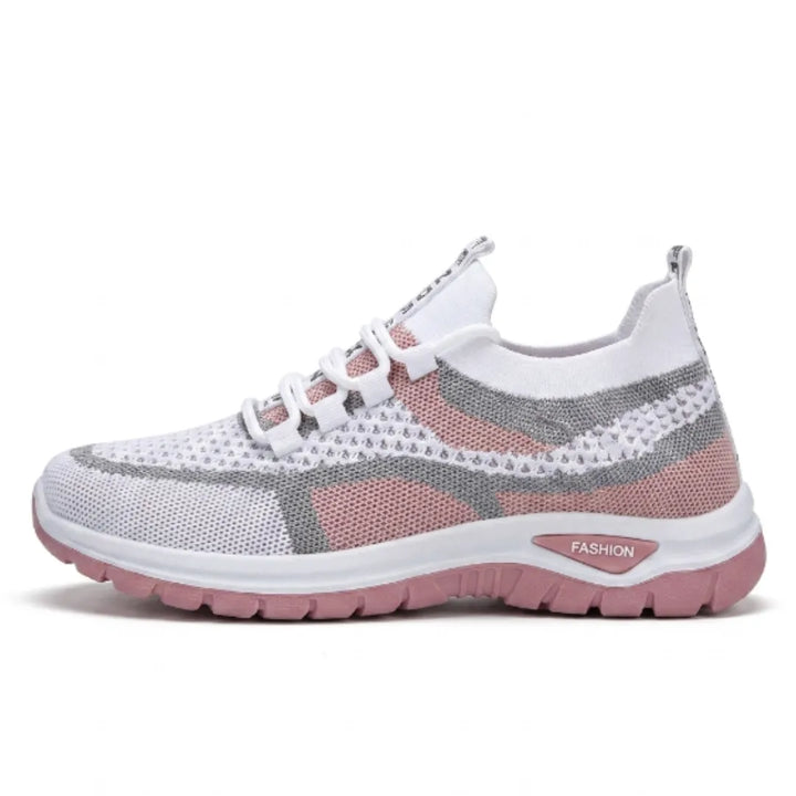 Zijaanzicht van een witte mesh sneaker met roze zool en grijze accenten, op een witte achtergrond. 19
