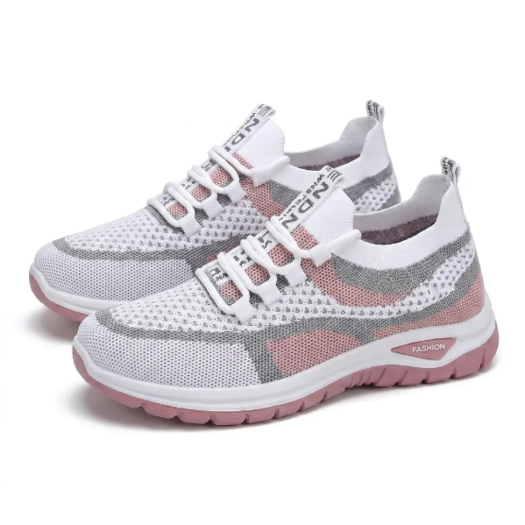 Paar witte sneakers met grijs en roze mesh, schuin van voren gezien met elastische veters en roze zool. 25