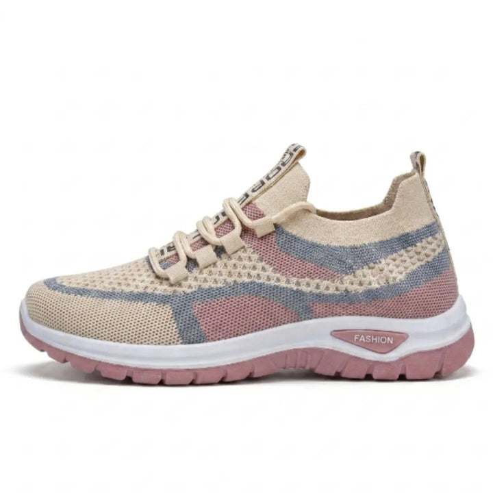 Zijaanzicht van de beige sneaker met roze en blauwgrijze mesh, witte tussenzool en roze loopzool. 28