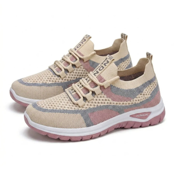 Paar beige sneakers met roze en blauwgrijze mesh, schuin van voren gezien met elastische veters en roze zool. 34