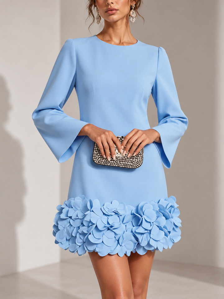 Lichtblauwe jurk van voren gedragen, met clutch in beide handen en een zoom vol 3D-bloemen. 5