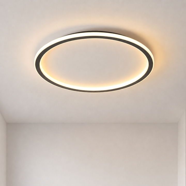 Aangezet als ringvormige plafondlamp met warm licht tegen een lichte plafond en wanden, vlak gezien zonder meubels. 1