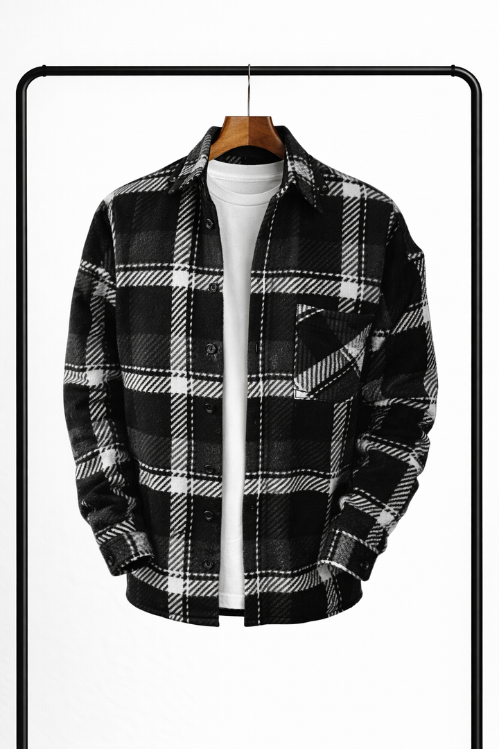 Zwart-wit geruit overhemdjack aan een houten kleerhanger, open over een wit t-shirt, met borstzak en donkere knopen. 3
