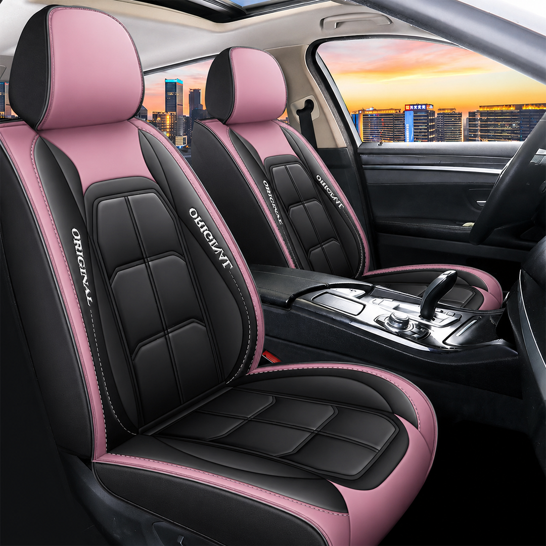 Twee voorstoelen met zwart-roze hoezen en witte siernaden in een auto, met een stadsgezicht bij zonsondergang. 14