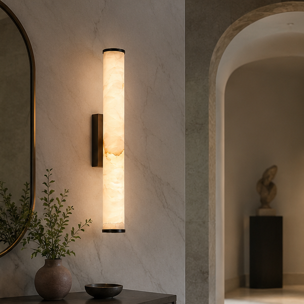 Verlichte marmeren wandlamp met zwarte afwerking in een gang met marmerlook muur, een boogdoorgang en een vaas met takjes op een console. 5