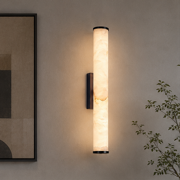 Lichtgevende marmeren wandlamp met zwarte uiteinden en zwarte wandplaat naast een ingelijst abstract schilderij en een plant. 3