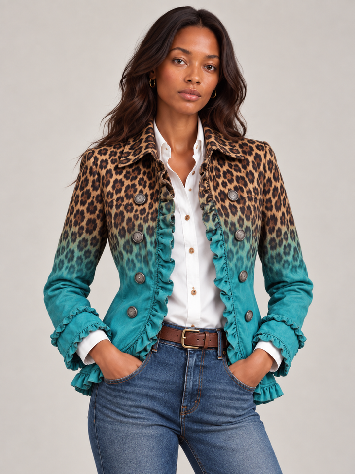 Close-up van een model in de blazer met luipaardprint die overloopt in turquoise, met volants en knopen, over witte blouse en jeans. 1