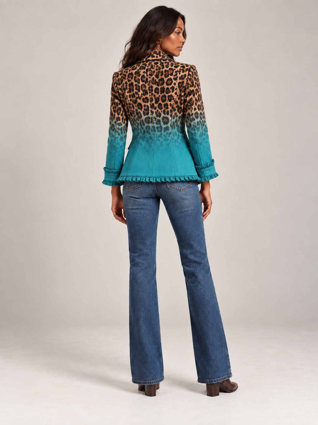 Achterkant van de turquoise blazer met luipaardprint, met volant langs de onderrand en de mouwboorden, gedragen door een model. 3