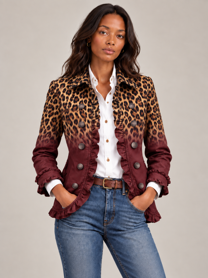 Close-up van de blazer met luipaardprint in kleurverloop naar bordeauxrood, met volants en knopen, over witte blouse en jeans. 11