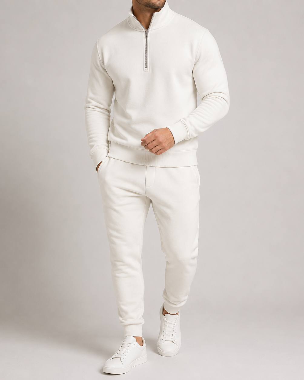 Model in gebroken wit trainingspak met opstaande kraag, halve rits en witte sneakers 4