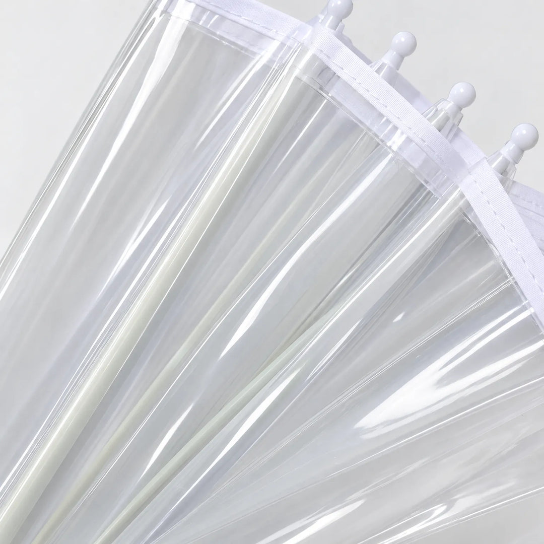 Close-up van het heldere plastic doek met witte rand en de witte knopjes aan de uiteinden van de baleinen. 4
