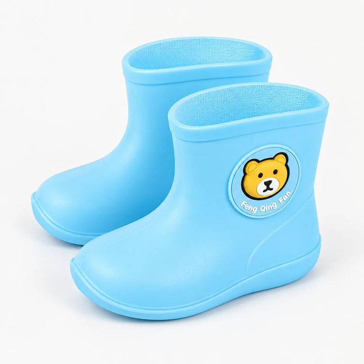 Lichtblauwe kinderregenlaarsjes met beertjesapplicatie, schuin van voren gefotografeerd op een witte achtergrond, met zachte blauwe binnenkant. 2