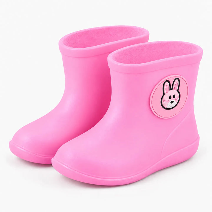 Paar roze regenlaarsjes met een konijntje op de schacht, schuin van voren gefotografeerd tegen een witte achtergrond. 9