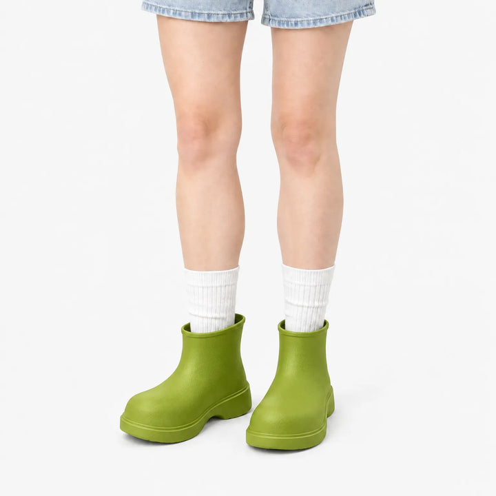 Groene enkellaarzen gedragen met witte sokken en korte spijkerbroek, frontaal model op witte achtergrond. 10