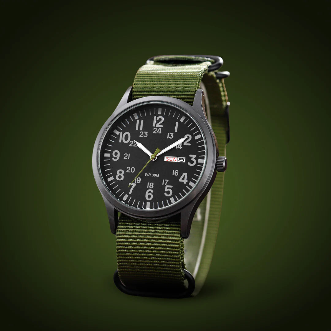 Horloge schuin gefotografeerd op een donkergroene achtergrond, met zwarte wijzerplaat, dag-datumvenster en groene geweven band met zwarte ringen. 4