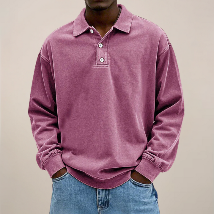 Model draagt het poloshirt in roze-paars, voorkant met kraag en knoopsluiting, gecombineerd met een lichtblauwe spijkerbroek. 10