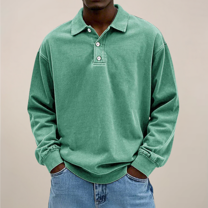 Model draagt het poloshirt in mintgroen, voorkant met knoopsluiting, lange mouwen en een losse pasvorm met spijkerbroek. 9
