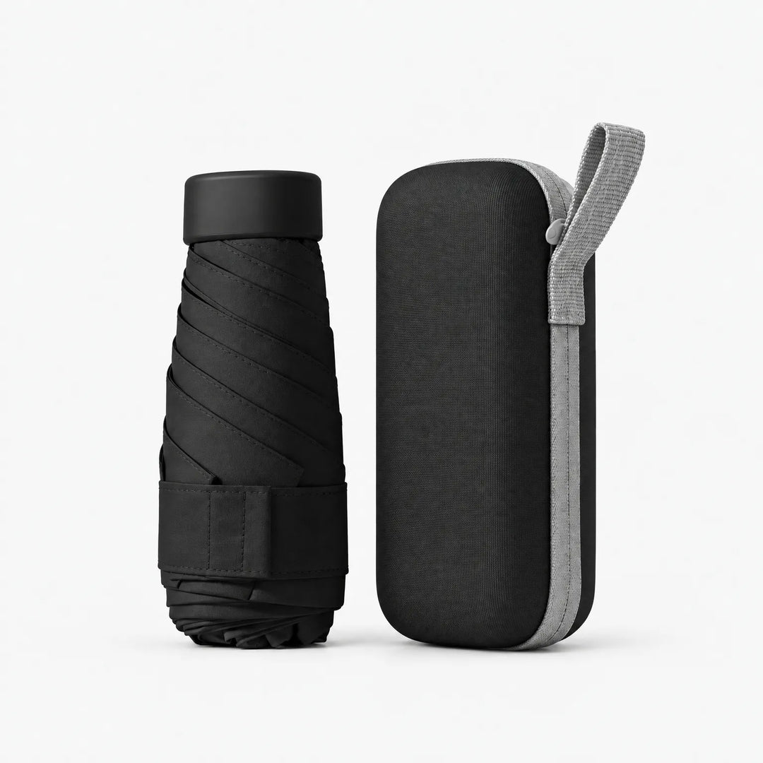 Dichtgevouwen zwarte paraplu naast het zwarte etui met lichtgrijs polsbandje en rits. 12