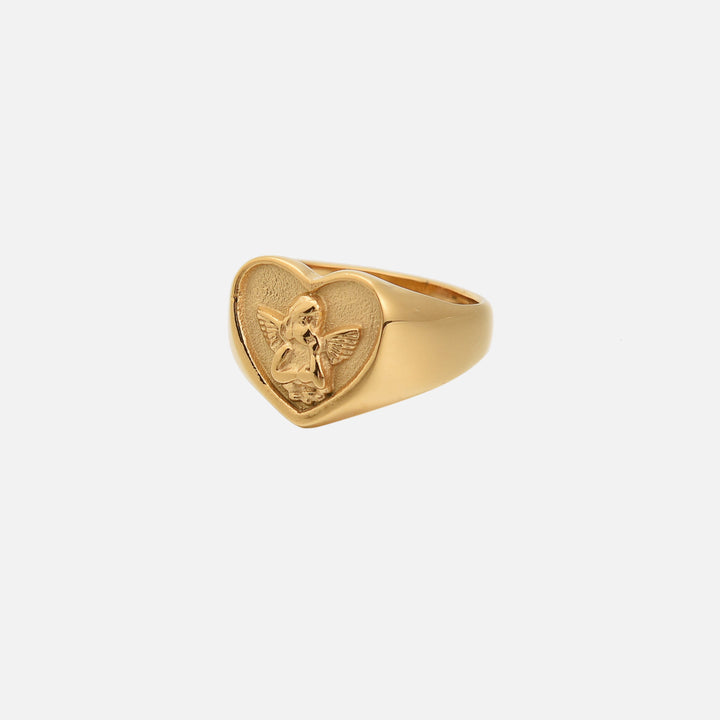 Gouden zegelring met hartvormige kop en een reliëf van een engeltje met vleugels, schuin van opzij op lichte achtergrond. 1