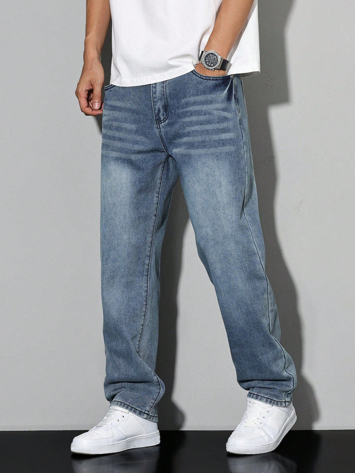 Middenblauwe vintage-look jeans met vouweffecten bij de heupen, gedragen met wit t-shirt en witte sneakers. 9
