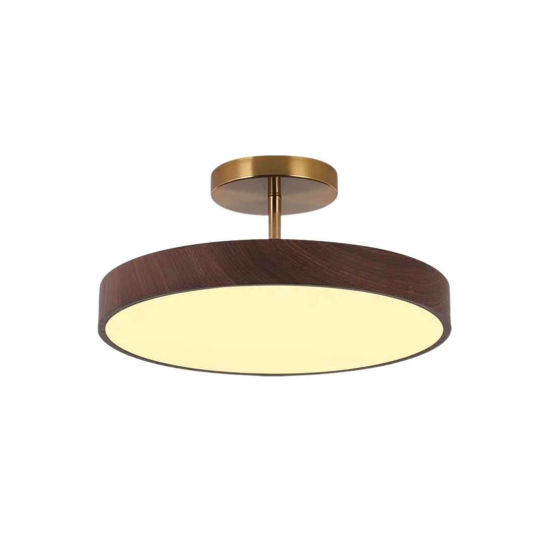Ronde plafondlamp met donkere houtlook rand en gouden steun, brandend op een neutrale witte achtergrond. 2