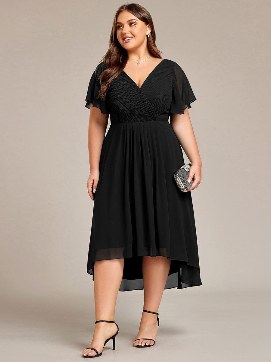 Frontaal beeld van de zwarte jurk op een curvy model dat een klein strass-tasje vasthoudt. 30