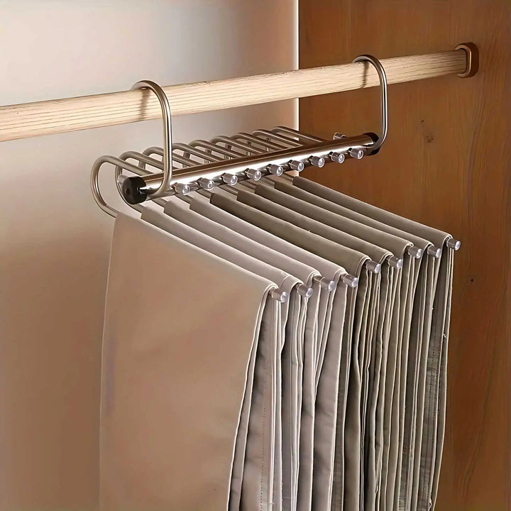 Ingeklapte metalen hanger aan de kastroede, waarbij de broeken dicht naast elkaar hangen en weinig ruimte innemen. 5
