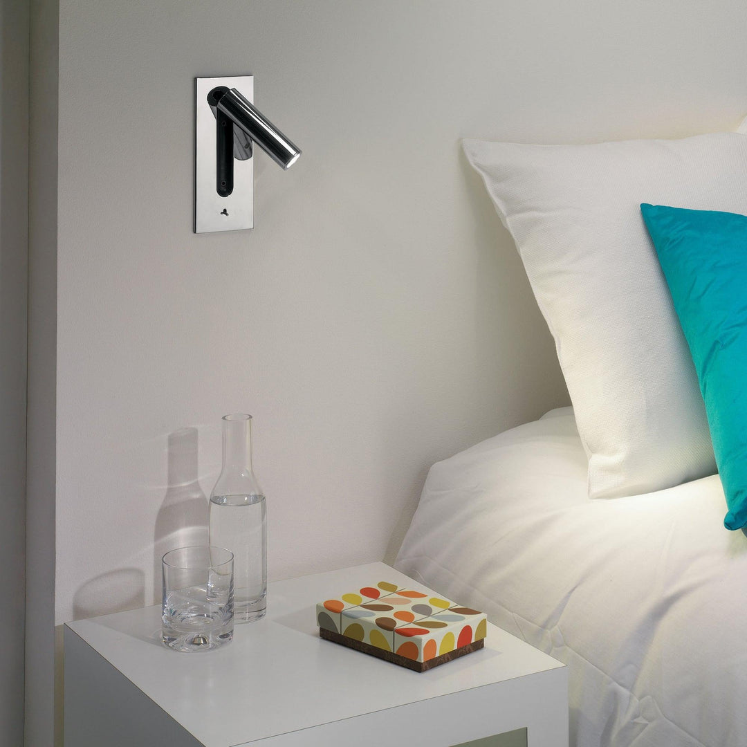 Donkere wandlamp met uitgeklapte, uitgeschakelde cilinder naar rechts, schakelaar onderaan, tegen een lichte muur 7
