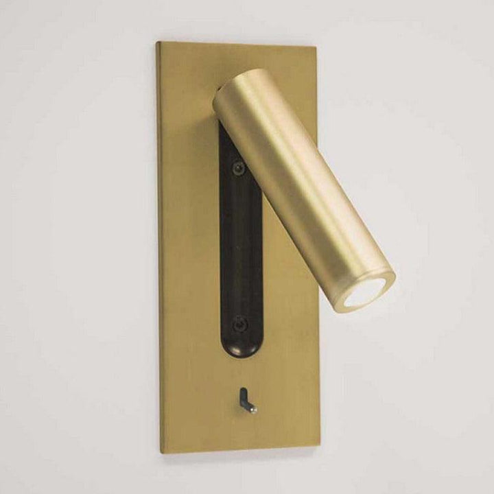 Wandlamp met gouden plaat en cilinder, spot naar rechtsonder gericht, zwarte sleuf en schakelaar 26