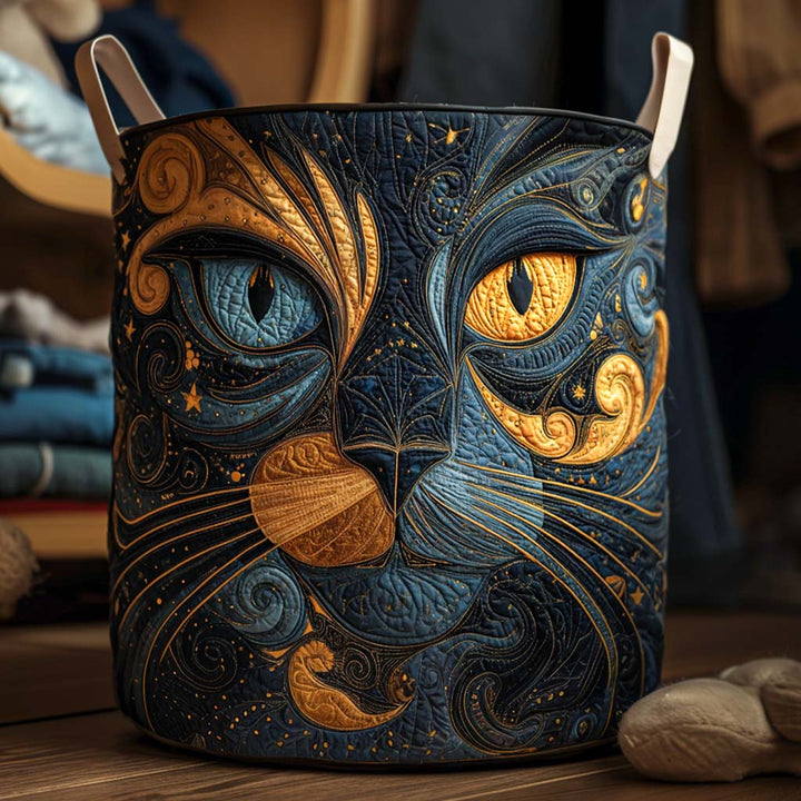 Gewatteerde ronde mand met een groot blauw-gouden kattengezicht en crèmekleurige handgrepen, close-up op een houten vloer met opgevouwen kleding erachter. 1