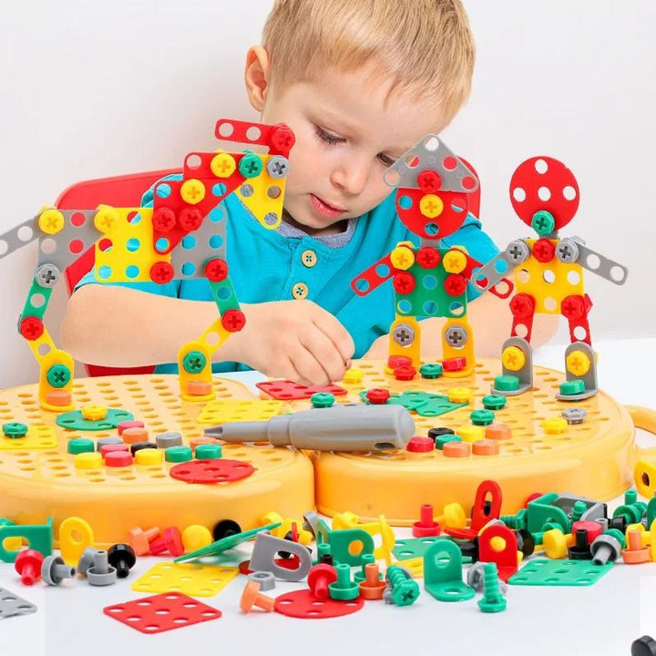 Jongetje bouwt aan een tafel drie kleurrijke robotfiguren van plaatjes en schroeven op de gele bouwplaten, met een schroevendraaier ertussen. 2