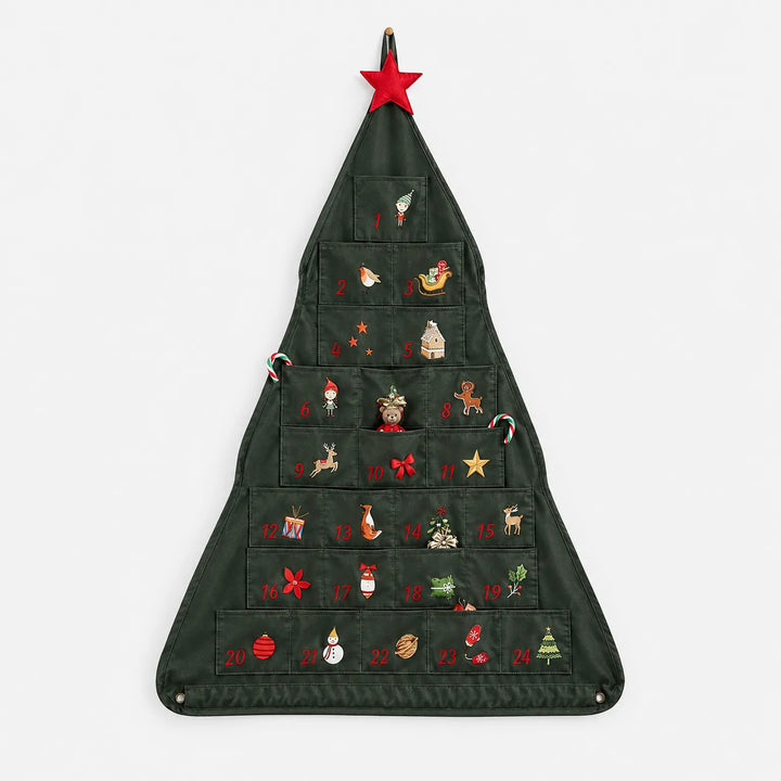 Voorkant van de donkergroene kalender in boomvorm met 24 genummerde vakjes, kleine kerstfiguurtjes, snoepstokjes en een rode ster, op een witte achtergrond. 2